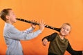 The boy plays the clarinet in the girlÃ¢â¬â¢s ear, the outraged girl waves her arms